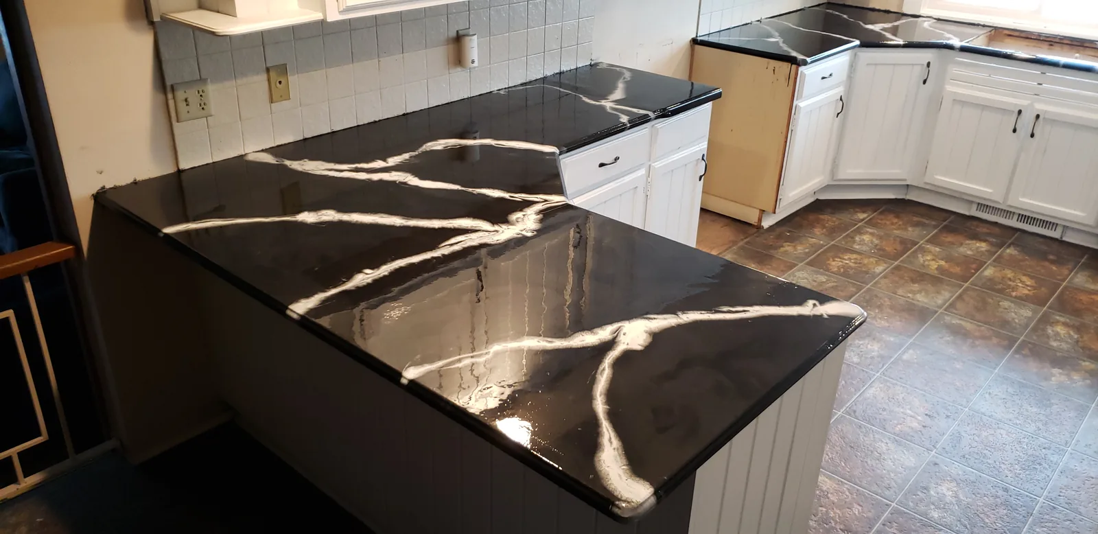 Epoxy restored kitchen countertop in a black marble look