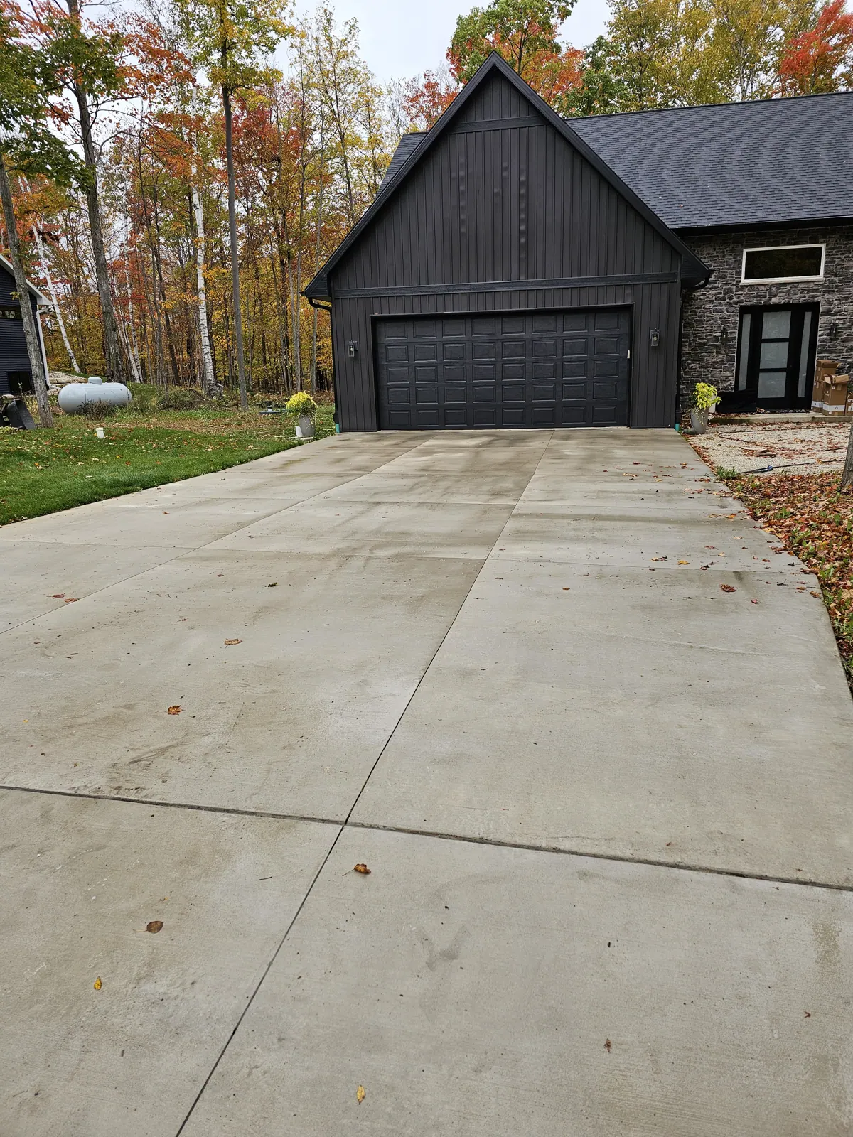 Freshly power washed concrete driveway in front of a dark garage door